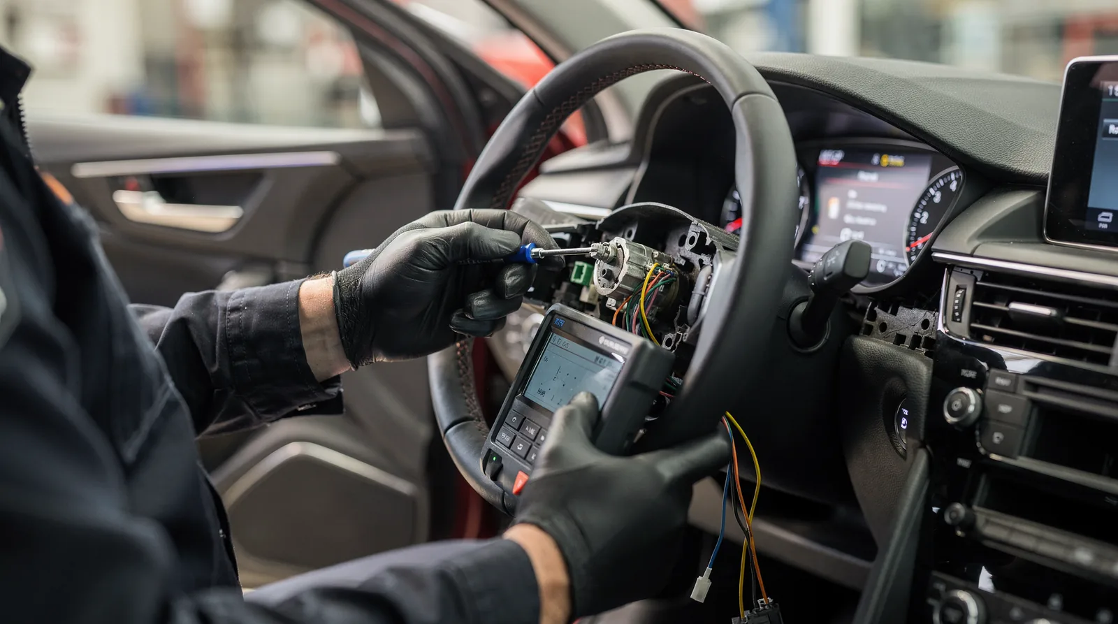 Automotive locksmith repairing ignition cylinder in car dashboard, San Antonio, TX.